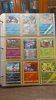 Photo showing 9 Pokemon cards displayed in a binder plastic sleeve page.