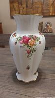 Full view of the white porcelain Royal Albert vase with floral rose pattern and gold accents