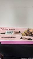 Pink box of professional curling iron labeled 'Professional curly hair',' showing packaging and product name