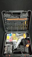 Full drill set shown open with assorted drill bits, screwdriver bits, power nuts, flexible drill shaft extension, and cordless drill in black carrying case.