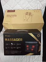 Photo showing the NAIPO Shiatsu 3D Rotating Massager box on top and the Twoqqw massager box underneath on a white quilted surface.