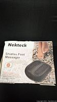 Front view of the Nekteck Shiatsu Foot Massager box showing product image and branding.