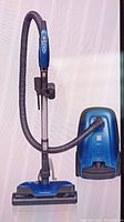 Assembled vacuum showing canister, hose, wand and floor brush