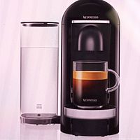 Front view of black Nespresso VertuoPlus espresso machine with water tank and coffee cup.