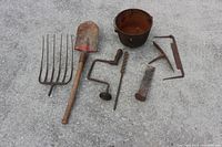 Group view of all antique iron tools on ground showing all items together