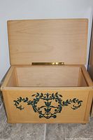 Open view of maple chest trunk showing plain maple interior and lid with brass hinge