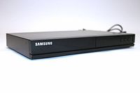 Front and right angle view of the Samsung E360 DVD player showing brand logo and control buttons.