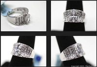Four images of a wide band sterling silver ring with marquise cut center simulant diamond and rows of round and emerald cut simulant diamonds on each side.
