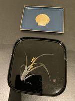 Both trays shown together on a surface, highlighting size and design difference.