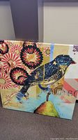 Angle view of the 35" square mixed media artwork showing a bird and colorful floral background.