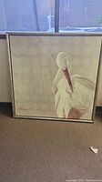 Framed artwork of a white bird with red beak, signed lower left, 52 inches square.