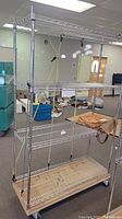 Full view of the metal wire storage rack with wooden base and casters in an indoor space