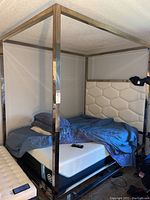 4-post stainless steel Kane bed frame with white padded headboard showing mattress and bedding