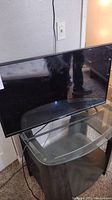 Element 32 inch flat screen television, front view showing screen and stand.
