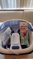 Homedics foot bath with Miracle Foot Repair cream box and components visible inside foot bath.