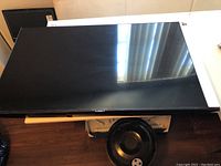 Front view of the 48-inch Samsung flat-screen TV resting on a table, showing screen and black bezel.