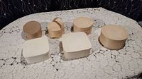 Photo showing six gift boxes on a lace tablecloth. Five are light natural wood and one is cardboard.