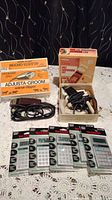 Lot shows an Adjusta-Groom animal clipper with original box and accessories alongside six Sharp handheld 10-digit calculators, mostly in packaging.