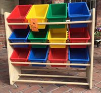 Front view of the wooden rack fully loaded with 12 colorful plastic bins showing all colors and tier setup.