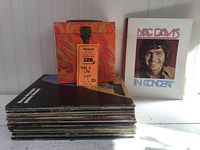 Stack of vinyl albums with a decorative box and Mac Davis concert album shown separately