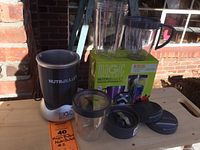 Full view of Nutribullet base, blending cups, lids, extractor blade, and original box with label #2
