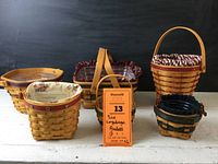 Collection of six Longaberger baskets with different sizes, colors, and liners