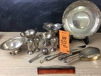 Full lot arranged on tabletop showing platter, compote, bowls, goblets, strainer, spoon, brush and comb