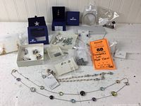 Wide shot of the lot showing multiple pieces of Swarovski jewelry, including boxed and unboxed items