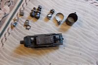 Overall view of the lot showing the crank up jack, trailer balls, and assorted truck hardware on a fabric surface