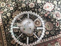 Top view of chandelier showing circular chrome frame and wiring for bulb holders, with glass balls encircling base.