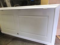 Full view of the white two-panel solid core door attached to door jamb with bottom door sweep.