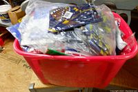 Red tote filled with new flags, showing folded colorful flags inside.