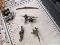 Overview of vintage tools including balance beam scale, rotisserie motors, and various metal tools arranged on carpeted floor.