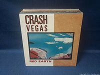 Stack of vinyl records with Crash Vegas 'Red Earth' album cover visible