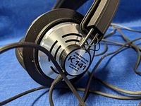 Close-up photo showing AKG K141 label on ear cup marked 'PRO OUTPUTS 1K-800 OHMS K141 MADE IN AUSTRIA'