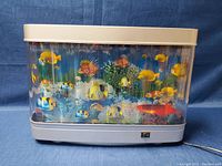 Front view of the lamp showing colorful fish and coral in a stable position with beige top and bottom frame.