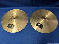 Both 14-inch diameter CB high hat cymbals placed side by side showing the top surfaces with brand logo.