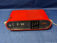 Front view of the red Toshiba digital flip clock radio showing the time and radio controls.