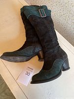 Pair of suede mid-calf boots side view showing color blocking and buckle detail