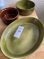 Top view showing three vintage ceramic bakeware pieces in green and brown glazes with some surface wear.