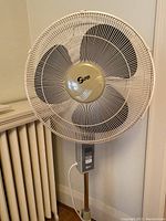 Close-up front view of the standing oscillating fan showing the brand Sunbeam and protective grille