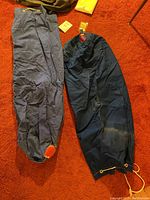 Photo showing two navy blue sailor sacks with drawstrings and leather bottom patches on an orange carpet.
