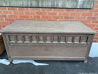 Closed wooden outdoor storage container showing decorative panel design on front