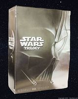 Front view of the Star Wars Trilogy DVD box set showing Darth Vader's helmet and embossed silver metallic design.