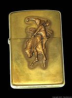 Front view of the brass Zippo lighter showing the raised cowboy on horse design.