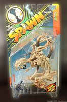 Full view of original packaging showing card and clear bubble containing Scourge figure and Nutnik figure in lower left corner, visible through bubble. Card shows Spawn Ultra Action Figures series branding.