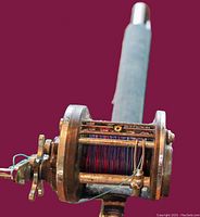 Close-up of Daiwa branded fishing reel spool loaded with fishing line, showing signs of usage.