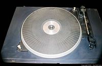 Top view of the vintage Soundesign record player turntable platter and tonearm on a black base.