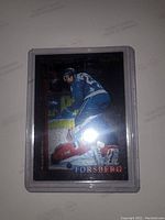 Front view of Peter Forsberg rookie holographic trading card in plastic holder showing player image and holographic effects.