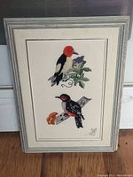 Front photo of the framed stitched bird artwork showcasing both birds.